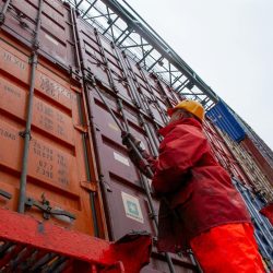Persona en un puerto de aduana revisando conteiners